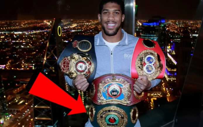 Anthony joshua memegang sabuk IBO